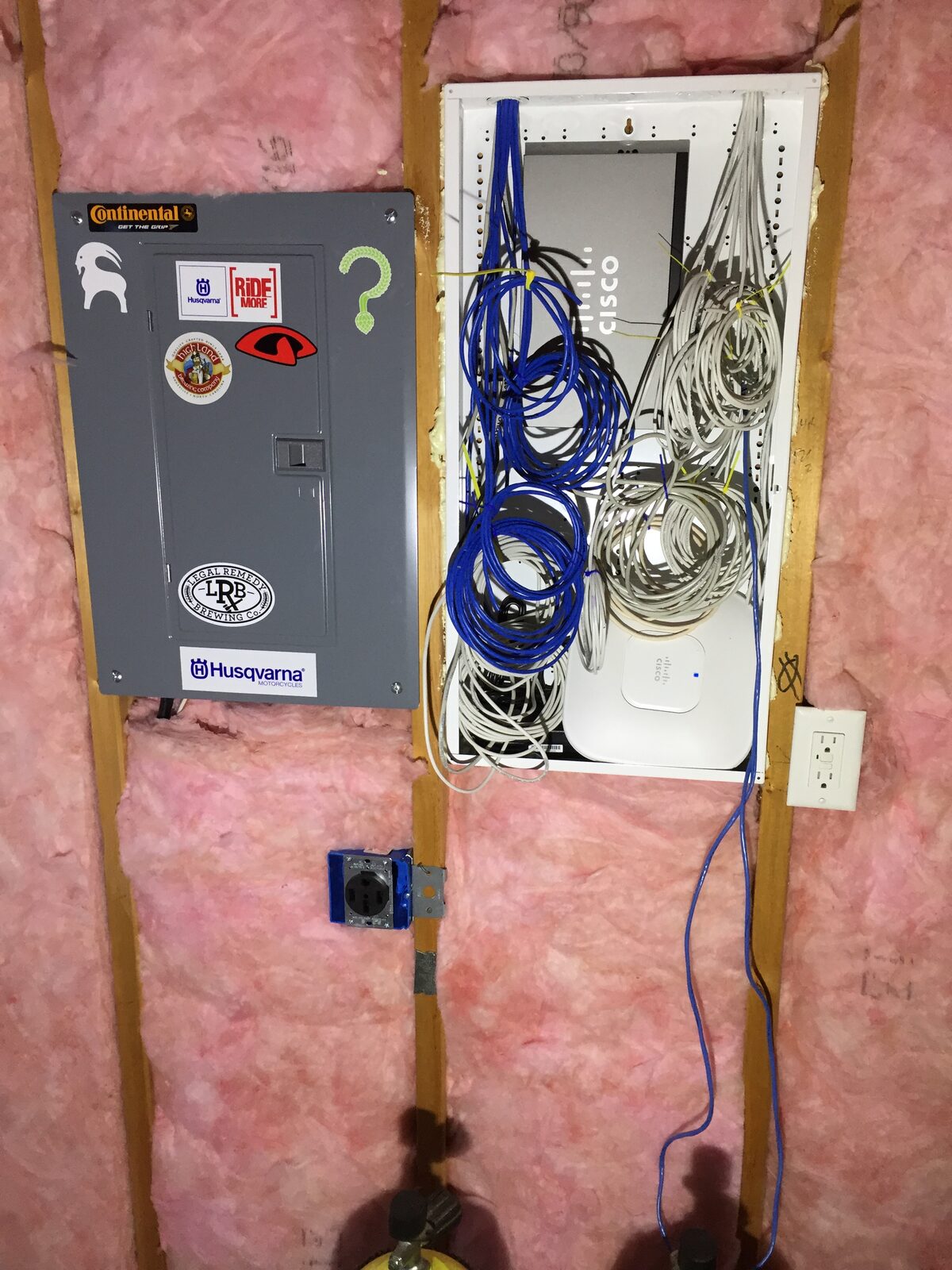 The workshop electrical panel and network enclosure in the open stud wall before drywall